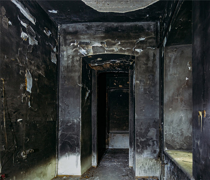 a fire damaged hallway with soot covering every wall
